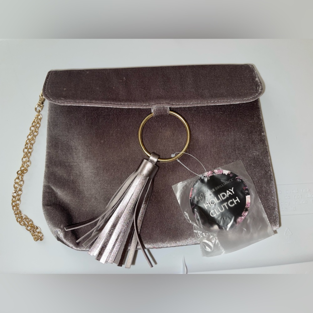 Chic wristlet with gold chain and tassel.